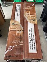 Two boxes of laminate flooring stacked showing branding, product line, and fold-over flap with usage instructions.