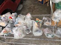 Photo showing multiple clown figurines wrapped in bubble wrap, displayed on a metal rack.