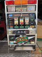 Front view of blue and black Lucky Chance slot machine with lighted signs and coin tray.