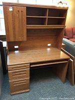 Desk with oak drawer fronts, doors, and tabletop on chipboard frame, featuring multiple drawers, open shelves, and cabinet door on the hutch.