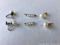 All six pieces laid out: two bar shorteners, two clip-on earrings, two stud earrings