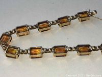 Close-up of citrine gemstone settings showing emerald cuts and gold mounting