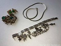 Overview of entire lot showing three bracelets, brooch, earrings