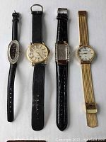 Four women's wristwatches arranged side by side on white background showing straps and faces