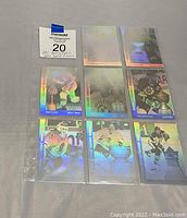 Top-down image of eight 1991 Upper Deck NHL Award Winners holographic cards in clear plastic sleeves laid out in a 3x3 grid with one missing card position. Cards show holographic shine and color with wear from use and age.