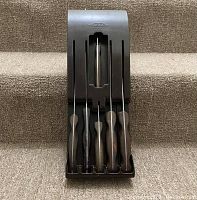 Front view of black plastic wall-mount case with five knives inserted