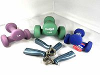Photo showing three pairs of dumbbells: a green Yes 4 All 5 lb set, a purple 2 lb set, a blue 2 lb Get Fit set, plus one pair of metal hand grips with blue plastic handles.