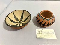 Two pottery pieces displayed side by side: a small pot and a bowl, with a business card identifying Albert Alvidrez from Ysleta Del Sur Pueblo