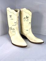 Pair of white leather Zodiac Frontier boots with Native American designs, side view