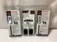 Front view of three new Tasco aluminum scope mounts TB70711 in retail packaging with visible labels and contents.