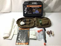Full contents of the advanced small arms cleaning kit with all accessories laid out beside the case and field pouch.