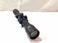 Front view of the Excalibur Drop Zone scope showing the lens, reticle markings, and overall condition.