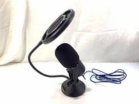 Clear image of Thronmax MDrill Zero Plus black USB microphone with foam cap, mounted on a round base stand and connected to a blue braided Type-C cable. Attached flexible pop filter positioned in front for sound clarity.