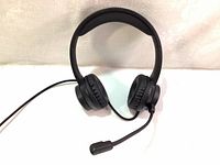 Front angle view of black Thronmax THX-20 USB headset showing adjustable headband, cushioned ear pads, and boom microphone on left side.