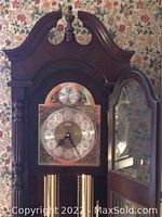Close-up of the ornate clock face with brass and silver detailing and clock hands.