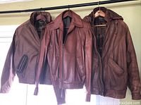 Three leather jackets hanging on a rack