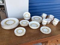 Full lot of Royal Doulton Polonaise china dishes, cups, and plates arranged on table