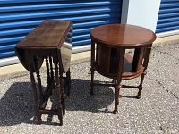 Drop leaf gateleg table folded with leaves down next to round rotating drum table, front view