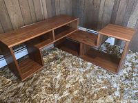 Two cherry-finished wooden shelving sections arranged showing modular compartments