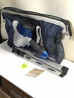 Front view of the air nailer in front of the carrying bag, nails placed in front unsealed on surface