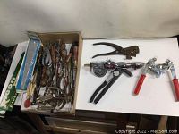 Tray filled with various vintage hand tools including the Dymo Mite tapewriter, bottle capper, rivet tool, punch, wood handled screwdrivers, clamp and pliers