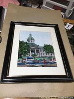 Framed mixed media painting showing a building with green dome and various boats in the harbor in front