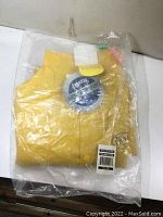 New yellow Pioneer rain coat folded and sealed in clear plastic bag, tags visible.