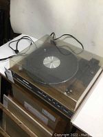Front angled view of Realistic LAB-440 turntable with closed transparent dust cover and visible power cord.