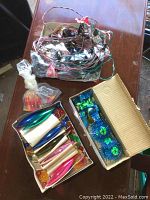 Overview of flame-shaped bulbs in box and plastic bag alongside bundled vintage string lights with wiring.