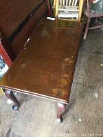Top angled view of the coffee table showing worn finish and scratches on the wooden surface.