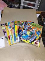 Grouped view of 10 vintage comic books showing various titles, publishers, and colorful covers including Spider-Man on motorcycle and others.