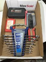 Photo showing all items together in cardboard box: Mastercraft wrench set in holder, black quick-change bit case, new packaged wire strippers, and red box of nut driver bits.