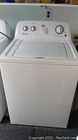 Front view of white top-load washing machine showing overall condition and lid closed