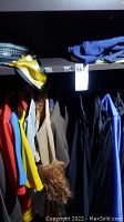 Shelving unit with assorted colorful costume jackets and coats hanging, showing various colors and textures including faux fur cuffs.