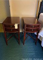 Pair of wooden two drawer end tables shown together from front, dark wood with round drawer pulls.
