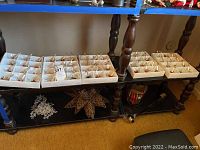 Sixty boxed Czech Republic clip-on candle ornaments displayed on a wooden rack shelf.