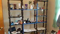 Full view of the shelving unit displaying various decorative items on multiple shelves showing overall structure and condition.