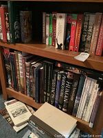 Bookshelf with history and Gettysburg related books, DVDs, and VHS tapes showing varied titles and conditions