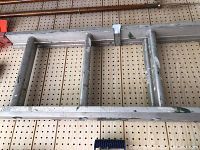 Close-up photo of metal ladder rungs showing paint splashes and surface wear.