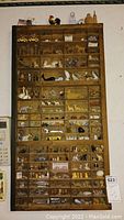 Full view of the wooden typeset box filled with miniature collectible figurines and objects