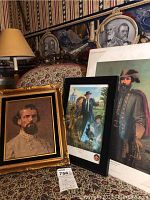 Overall view of three framed artworks including Lt. Gen. Forrest painting and two lithographs on a patterned fabric background