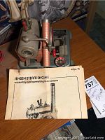 Photo showing Jensen Steam Engine model No. 76 with instruction manual on wooden surface.