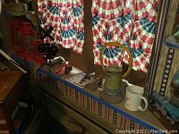 Wide view of the lot including the train signal, lanterns and additional collectibles on shelf in front of patriotic curtains.