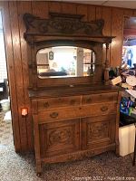 Front view of full oak sideboard showing mirror, drawers, carved detail, and bottom cabinet doors