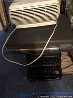 Holmes air purifier model HAP 240 placed on black briefcase with power cord visible