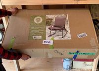 Photo of boxed folding outdoor rocker chairs with label showing brand Home Decorators Collection and rocker chair image