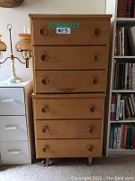 Two stacked matching wooden dressers with three drawers each, light wood finish, rounded knobs, labeled with measurements and lot number.