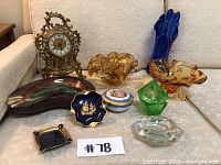 Set of 12 decorative items including glass pieces, porcelain ashtrays, and antique clock