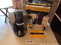 Full view of all items including Keurig coffee maker, K-Cup storage drawer in box, reusable filter, and Bodum milk frother with its box.