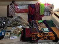 Overview of scarves laid out and some velvet hangers in packaging at corner